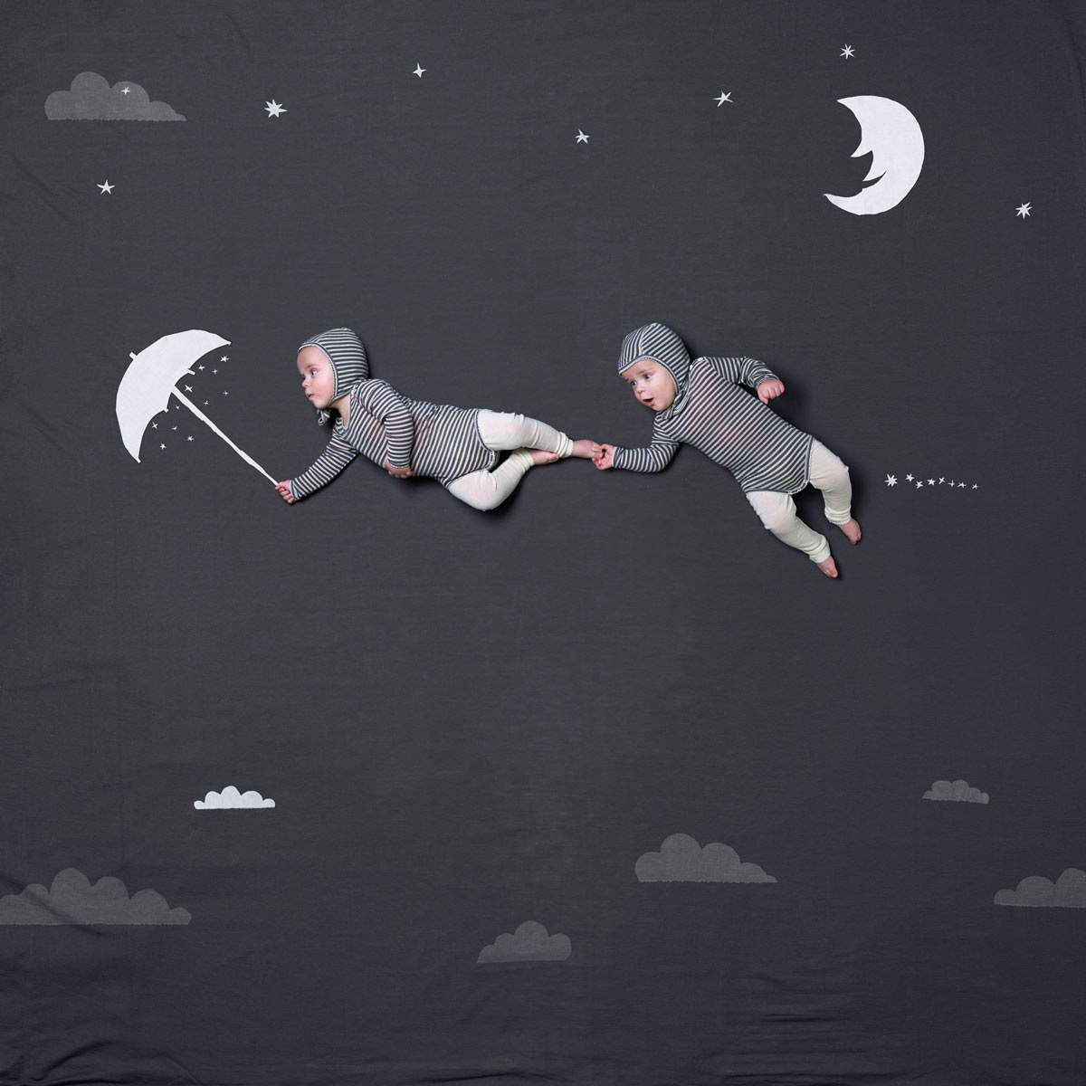 Twin boys in a magical world, flying in the air after an umbrella. Advertising for Norwegian wool brand Lilli Leopold by håvard schei